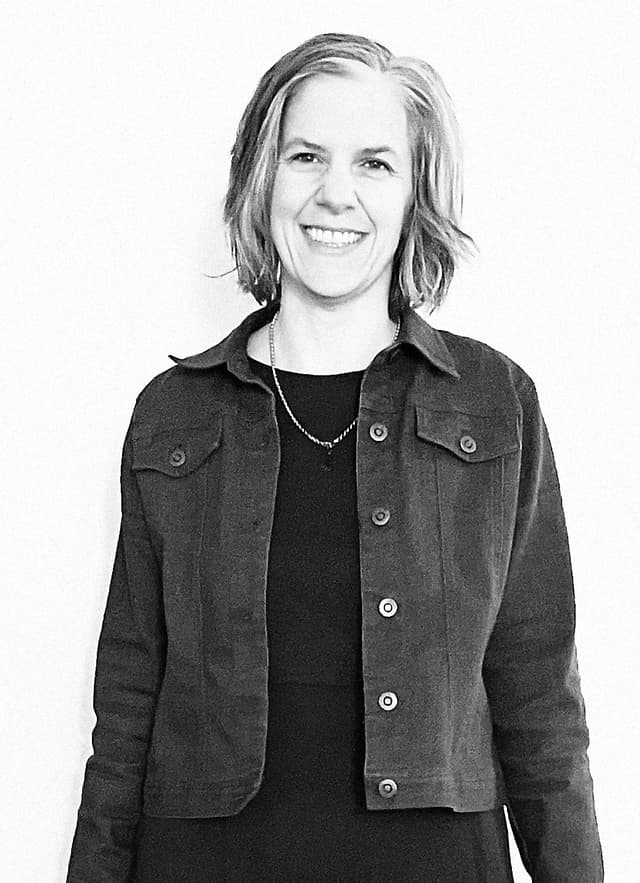 Maria Xavier smiling in front of a white wall
